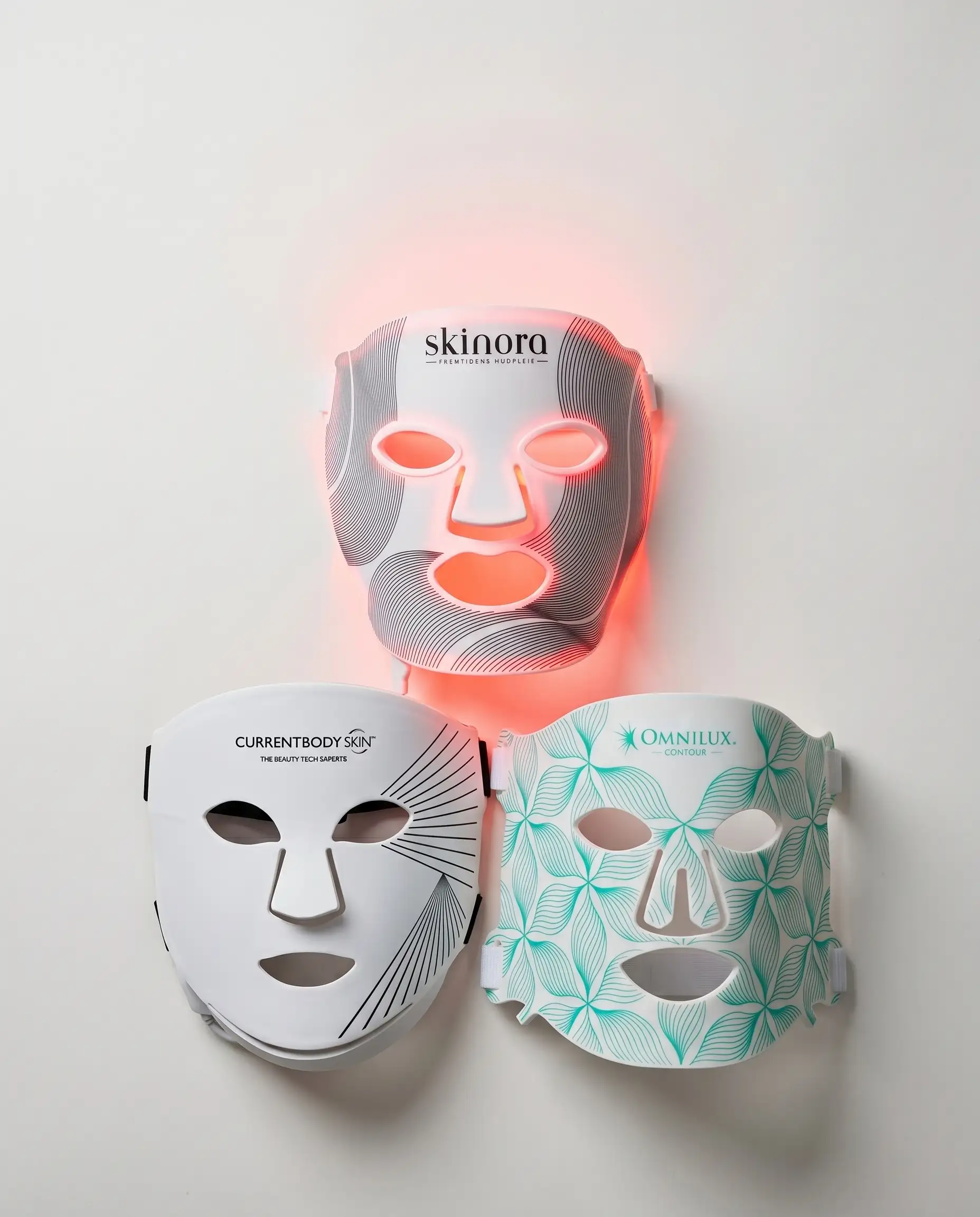 Skinora Radiance Face, CurrentBody Series 2 og Omnilux Contour LED-masker fotografert side om side.